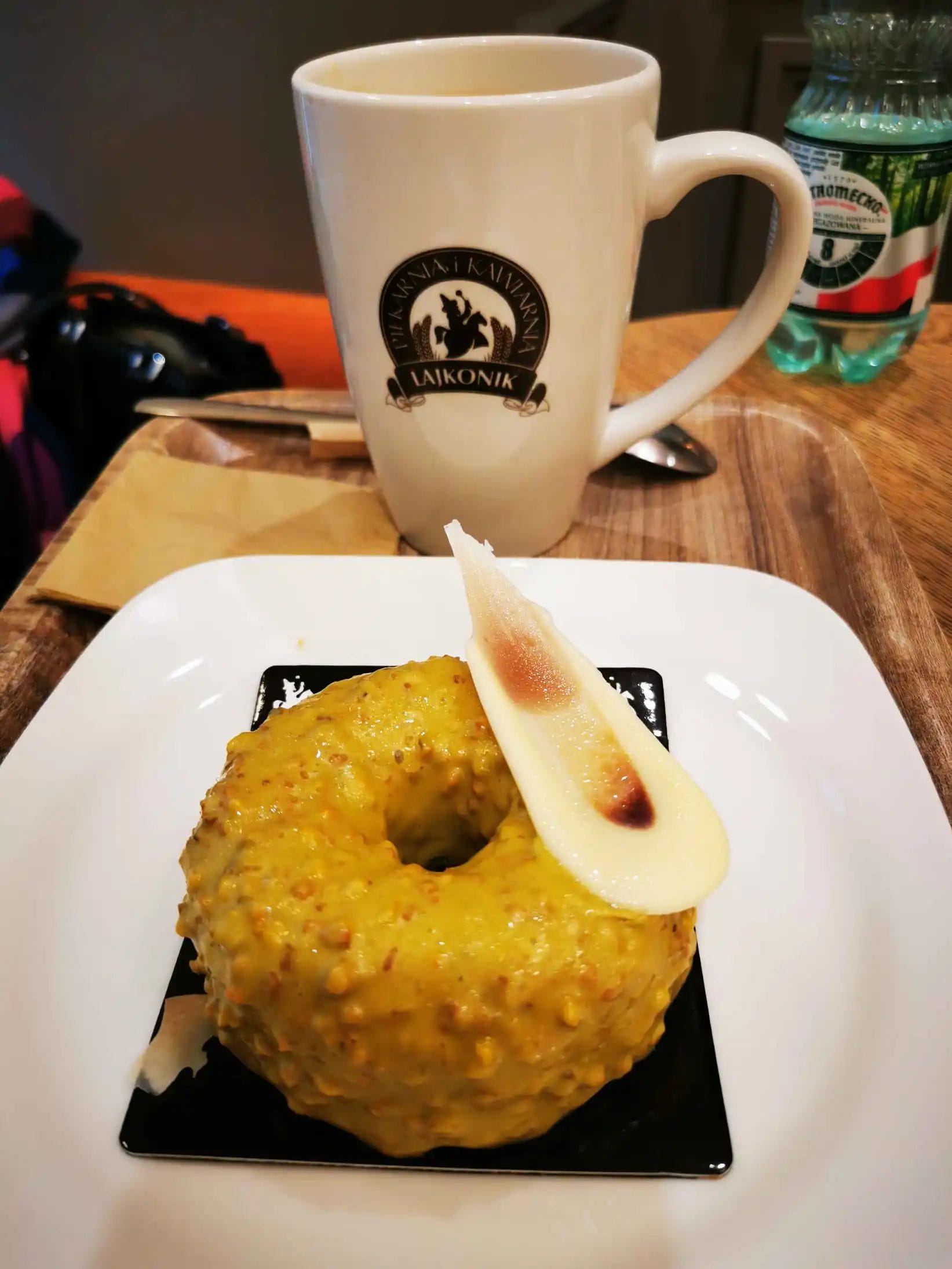 a donut on a plate with a cup of coffee